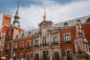 Low angle view of a historic building in Madrid, Spain with statues and classic architecture.